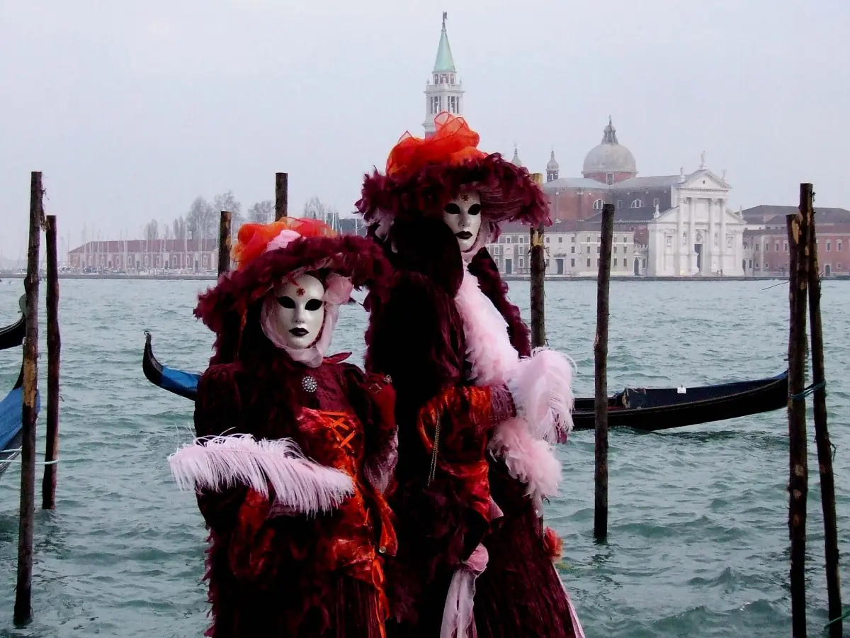 Karnevalskostüme an der Lagune, dahinter San Giorgio Maggiore